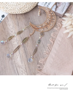 Detail of bohemian crescent moon wall hanging with citrine stones and agate slices