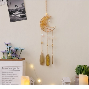 Detail of moon-shaped crystal wall decor with golden wire and natural agate stones