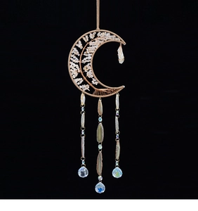 Detail of moon-shaped gold tree of life wall decor with pink quartz and agate slices