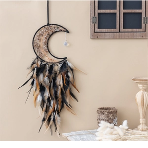 Detail of bohemian moon dream catcher with natural feathers and stones on a wall