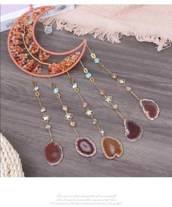 Detail of moon-shaped dream catcher with tree of life wire work and agate slices