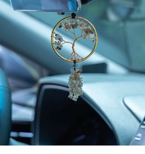 Close-up of handmade tree of life car charm with golden wire and natural citrine stones