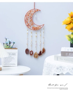 Detail of moon-shaped dream catcher with pink agate slices and bohemian copper wire design