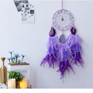 Detailed view of handmade purple dreamcatcher with agate slices and bohemian feathers