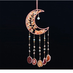 Detail of tree of life moon decor with agate slices and crystals on black background