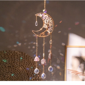 Macro detail of moon suncatcher with tree of life crystal wire wrapping and hanging prisms
