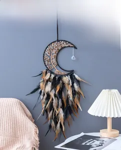 Detail of moon-shaped dream catcher with tree of life and black natural feathers