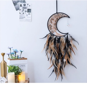 Detail of bohemian crescent moon dream catcher with life tree and feathers on a white wall