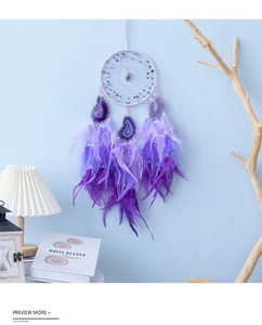Detailed view of handmade purple dream catcher with amethyst stones and soft feathers