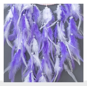 Detail of soft purple and white feathers with pearl beads on a handmade dreamcatcher