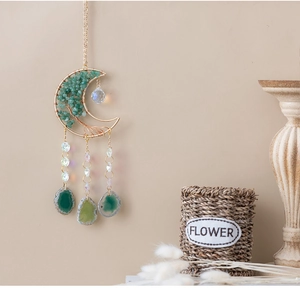 Detail van boho wanddecoratie met kristallen levensboom en groene agaat plakjes aan de muur