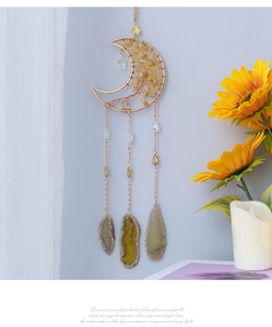Detail of moon-shaped crystal wall hanging with gold wire and natural agate slices