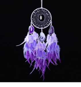 Detail of dream catcher with purple agate slices and soft gradient feathers decor