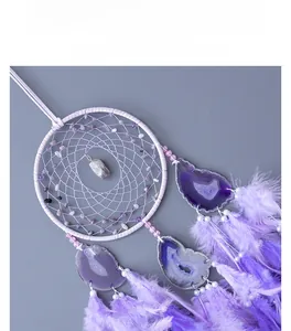 Detail view of purple dream catcher with amethyst stones, agate slices and feathers