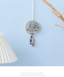 Macro shot of handmade Tree of Life wall hanging with natural stones and gold metal frame