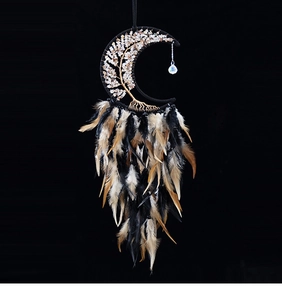 Detail of moon-shaped dream catcher featuring crystal tree of life and black feathers