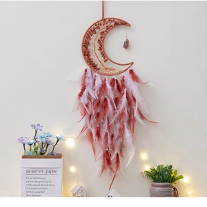 Detailed view of handmade moon-shaped dream catcher with life tree and soft feathers