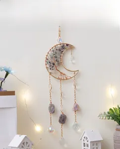 Moon shaped tree of life suncatcher with natural crystals and prism on a white wall