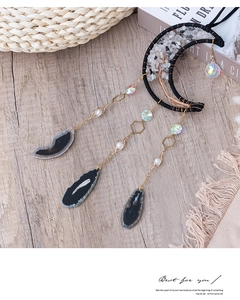 Bohemian crescent moon wall decor with natural crystals and agate slice on a wooden table