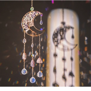 Close-up of handmade tree of life moon suncatcher with purple crystals and rainbow light
