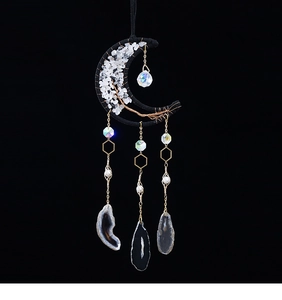 Detail of bohemian crescent moon dream catcher with white crystal and black agate slices