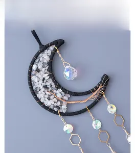 Detail of moon-shaped dream catcher with white crystal gravel and aurora bead pendant