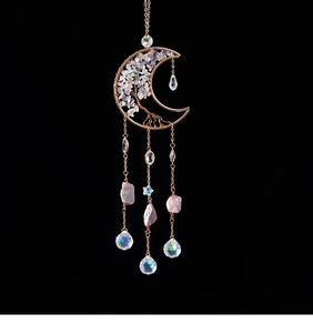 Detail of tree of life suncatcher with moon frame and hanging amethyst crystal prisms