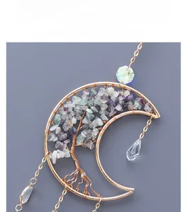Detail of handmade crescent moon tree of life suncatcher with purple and teal crystals