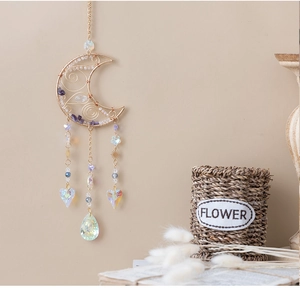 Detail of amethyst crescent sun catcher with gold wire wrap and crystal heart pendant
