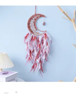 Detail of bohemian pink moon dreamcatcher with natural crystals and soft feathers