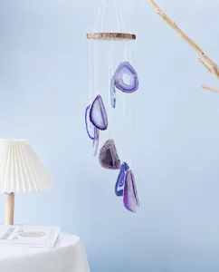 Macro detail of natural purple agate wind chime slices with rustic wooden base and strings