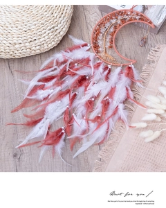 Moon-shaped dream catcher with pink feathers and life tree crystal design on wood