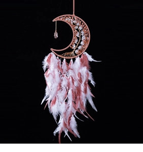 Detail of moon-shaped dream catcher with crystal tree of life and pink white feathers