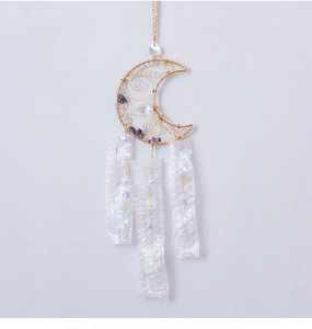 Detail of moon-shaped suncatcher with purple amethyst stones and gold wire wrapping