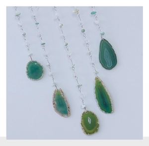 Detail view of four green agate slices with bohemian stone bead hanging chains