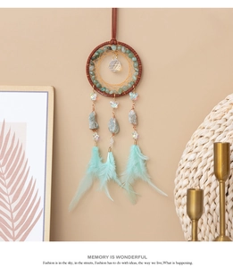 Detail view of turquoise dream catcher with healing crystals and mint green feathers
