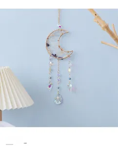 Close-up of moon-shaped amethyst suncatcher with golden wire wrap and crystal prisms
