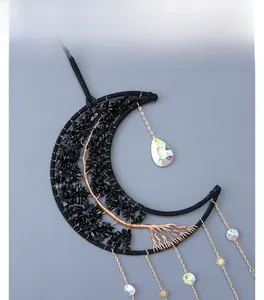 Détail d'un croissant de lune en obsidienne avec arbre de vie fait main en fil de cuivre