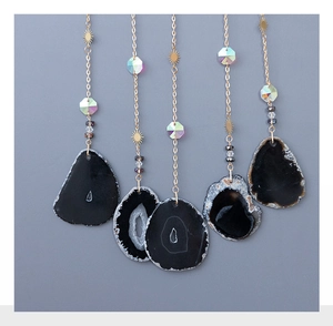 Détail du pendentif soleil arbre de vie avec pierres d'obsidienne et tranche d'agate noire