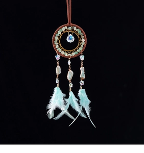 Detail of dreamcatcher pendant with turquoise stones, crystal ball and blue feathers