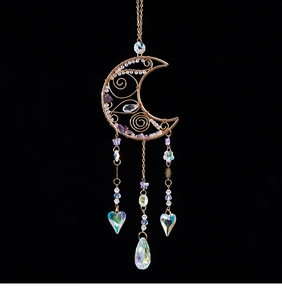 Detail of moon-shaped suncatcher with purple crystal chips and aurora heart pendants