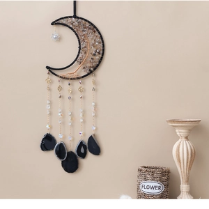 Detail of moon-shaped dream catcher with tree of life and black agate crystal slices