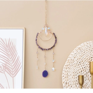 Detalle de atrapasueños lunar de amatista con cadenas doradas y colgante de ágata lila