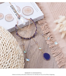 Detalle de atrapasol bohemio con piedras de amatista y rodaja de ágata color púrpura