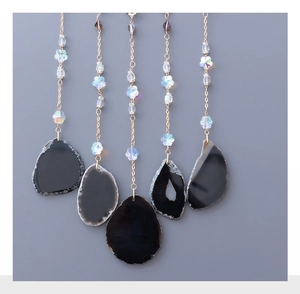 Close-up of golden chains with crystal beads and natural black agate slices for wall decor