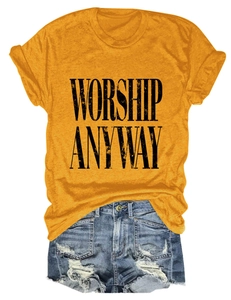 Close-up of Worship Anyway print on yellow tee with distressed denim shorts