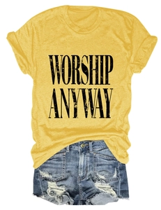 Flat lay of yellow Worship Anyway t-shirt paired with distressed denim shorts on white