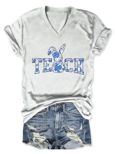 Close-up of V-neck T-shirt with TEACH floral bunny print and ripped denim shorts