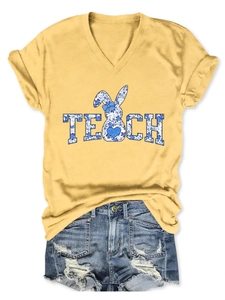 Detail of V-neck yellow tee with blue floral TEACH rabbit print and ripped denim shorts
