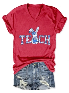 Flat lay of red V-neck T-shirt with TEACH rabbit print and ripped denim shorts